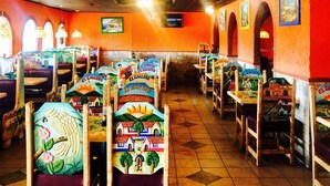 L’intérieur d’un restaurant présente de nombreux espaces de restauration, chacun décoré avec un motif peint original, et le sol est recouvert de carreaux.