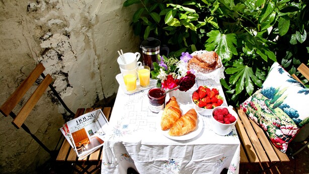 A breakfast table with croissants, strawberries, jam, and a coffee pot. - Charming one bed  flat near Brighton Station and short walk to North Laine (Brighton)