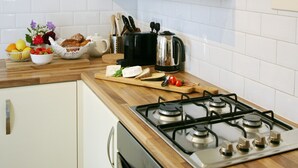 A kitchen with a gas stove, a kettle, and various food items on the counter. - Charming one bed  flat near Brighton Station and short walk to North Laine (Brighton)