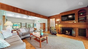 A living room with a fireplace, sofa, and television. - Holiday Hill Resort  "The Captain's Cottage" Unit 720 (Saugatuck)