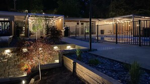 A modern outdoor area with a pool, wooden deck, and a covered seating area. - Holiday Hill Resort  "The Captain's Cottage" Unit 720 (Saugatuck)