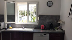 A modern kitchen with a large window, a dishwasher, a sink, and two bar stools. - Grillon in the Enclave des Papes, 4 km from Château de Grignan.  (Grillon)