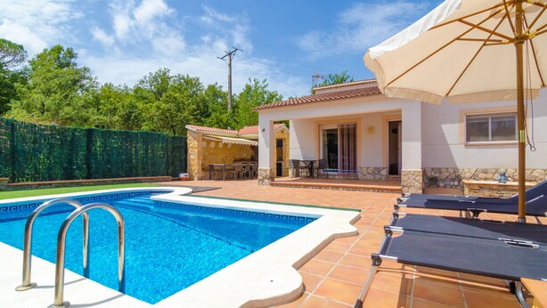 A swimming pool with a tiled deck, lounge chairs, and a covered patio area. - Club Villamar - Nice house, complete and very sunny, located in a quiet urbanization,with a  priv... (Vidreres)