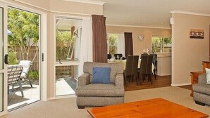 A spacious living area with a sofa, coffee table, and a dining area with chairs and a table.