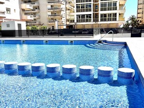 Relax by the rectangular pool surrounded by a black fence and blue-tiled steps.