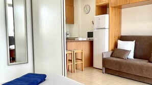 A compact room with a kitchenette, a sofa, and a small dining area. - APARTBEACH ADRIATICO RELAX BEACHFRONT WITH SWIMMING POOL AND PARKING (La Pineda)
