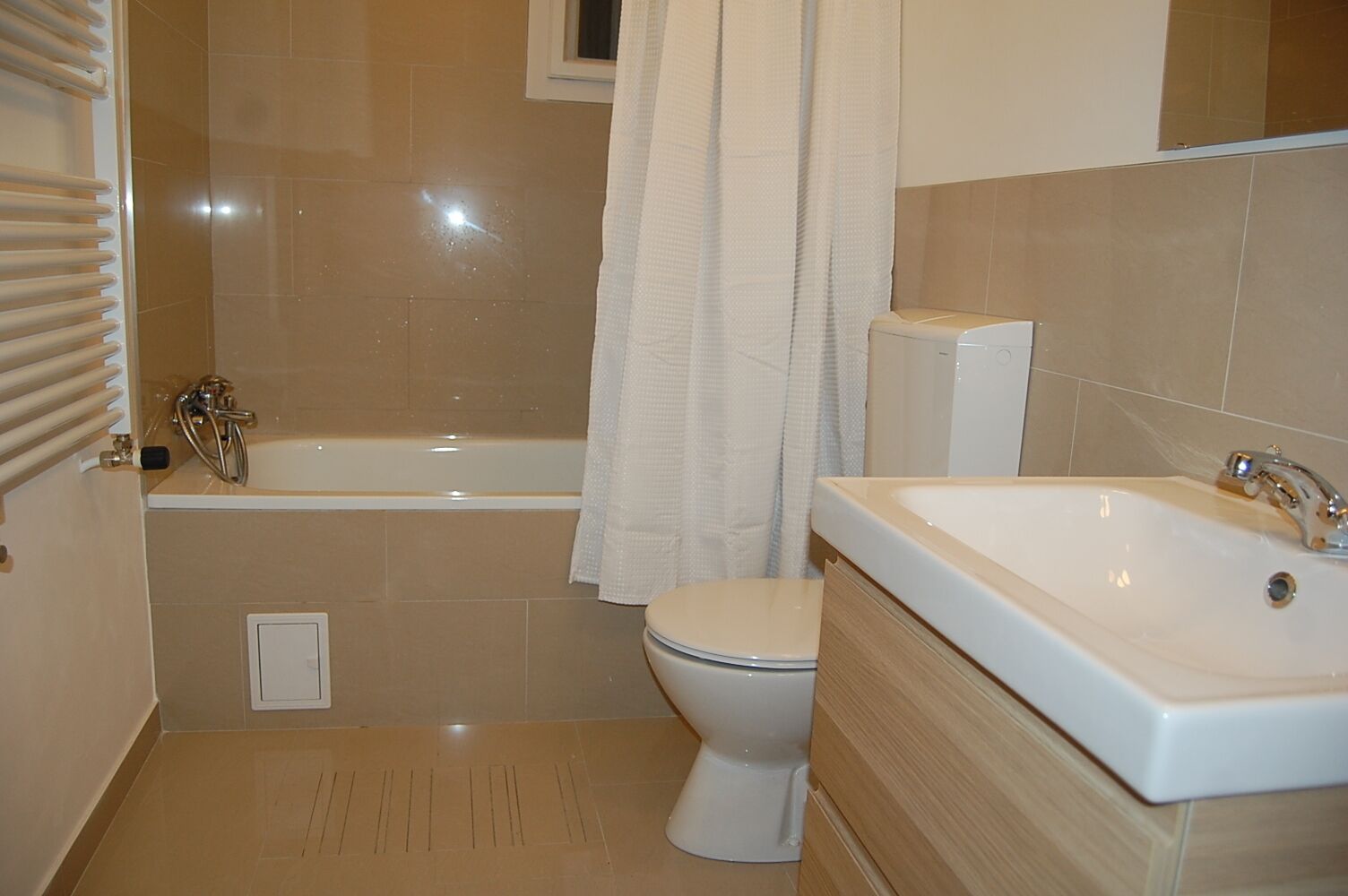 A bathroom with a bathtub, toilet, and sink.