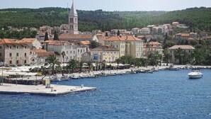 Une ville côtière dotée de bâtiments historiques, d’un clocher d’église imposant et d’un port de plaisance où sont amarrés des bateaux.