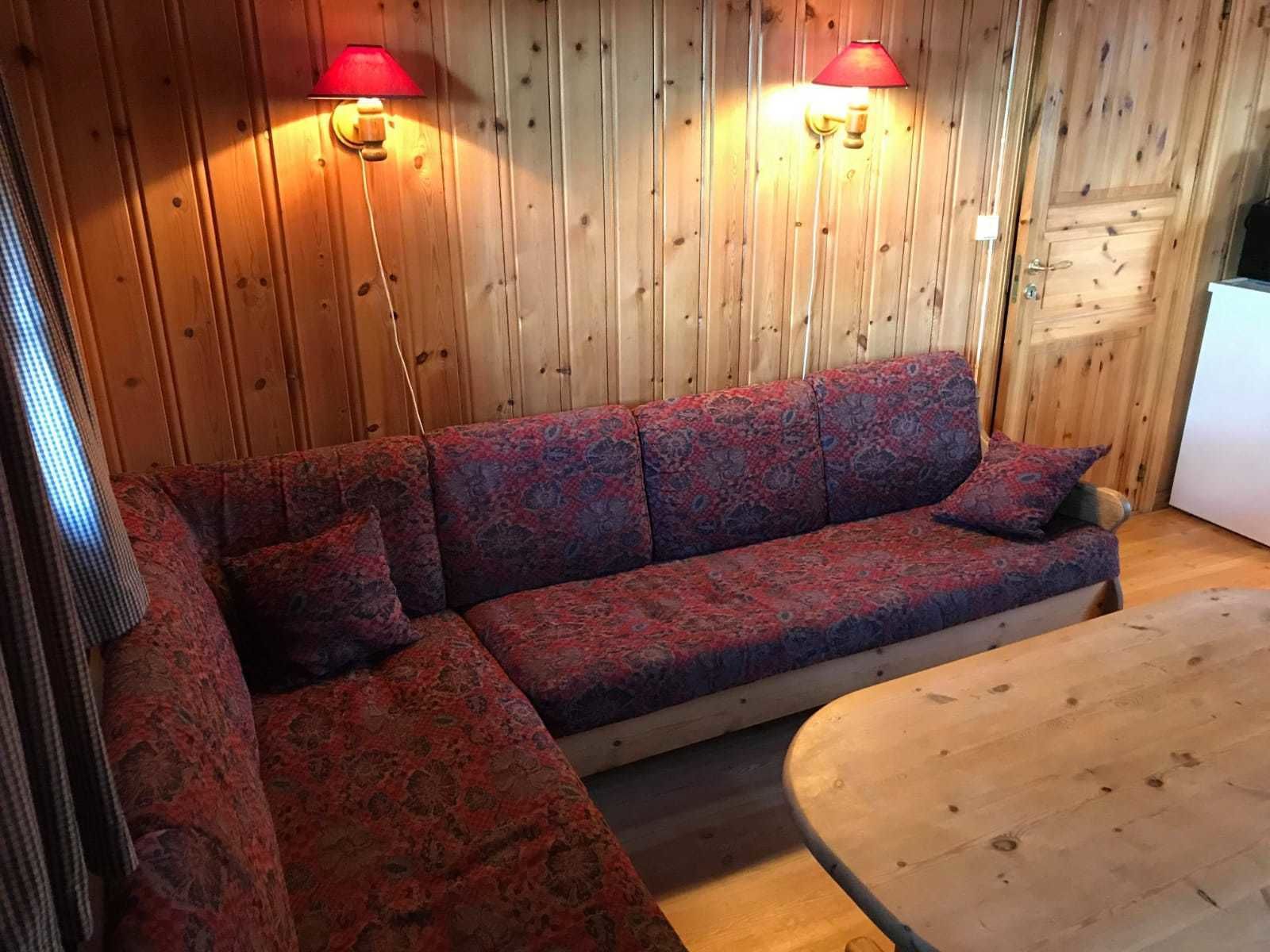 Un interior de madera con un sofá y una mesa redonda.