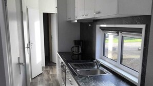 A modern kitchen with a black countertop, stainless steel sink, and a window providing a view outside. - O'Lin Lake Resort (Hole)