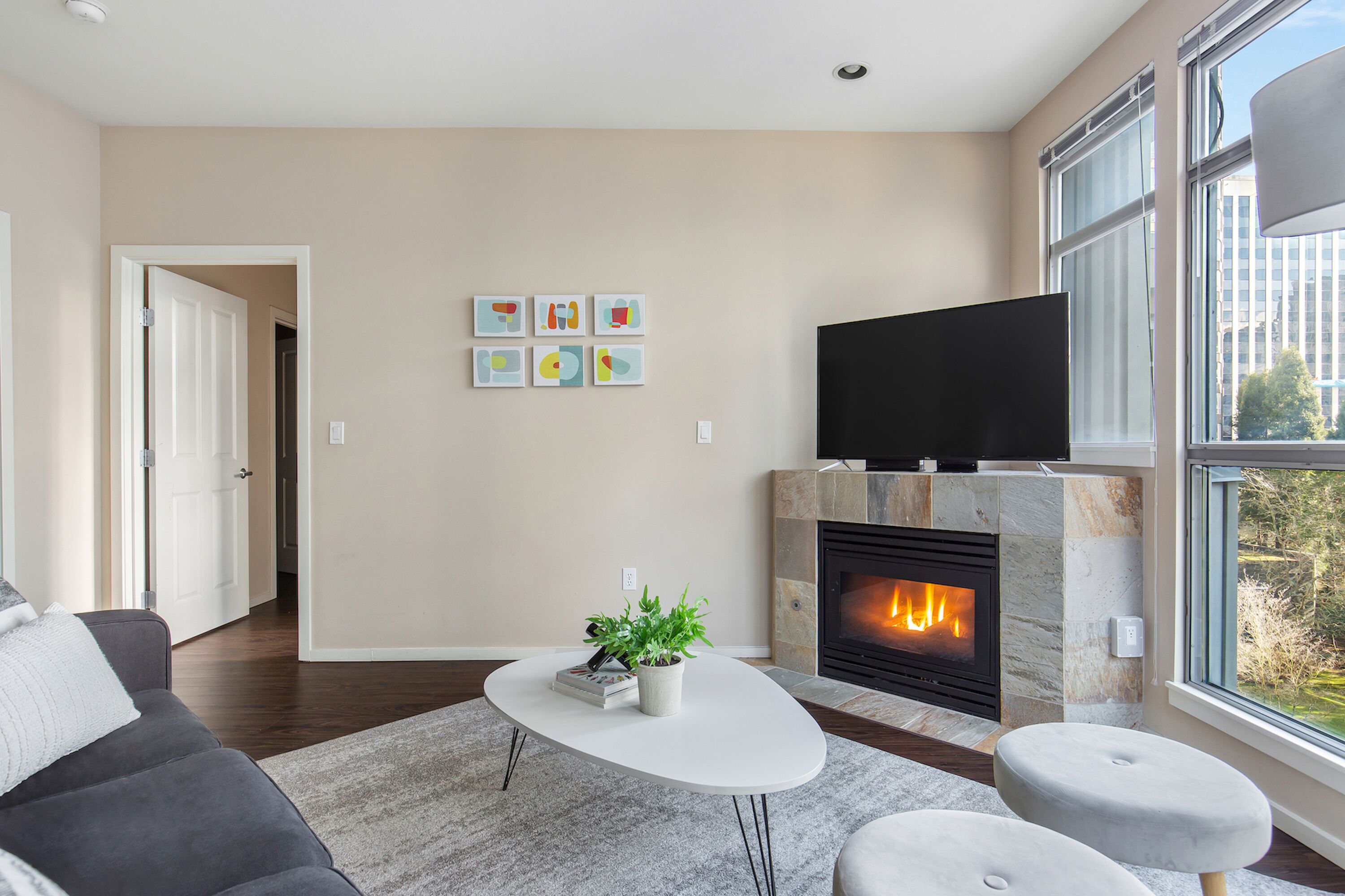 A modern living room with a fireplace, a flat-screen TV, and a sofa.