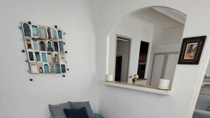 Ein Schlafzimmer mit einem Bett, einem Nachttisch, einem Spiegel und einer Wanddekoration.