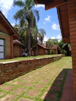 Um pátio com calçada pavimentada, edifícios de tijolo e uma palmeira.