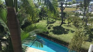 Una piscina circondata da palme e da un'area verde.