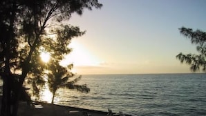 Ein Strand mit Blick auf den Ozean und einen Sonnenuntergang.