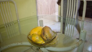A glass table with a bowl containing three fruits. - Belle Air Paradise JM (Runaway Bay)