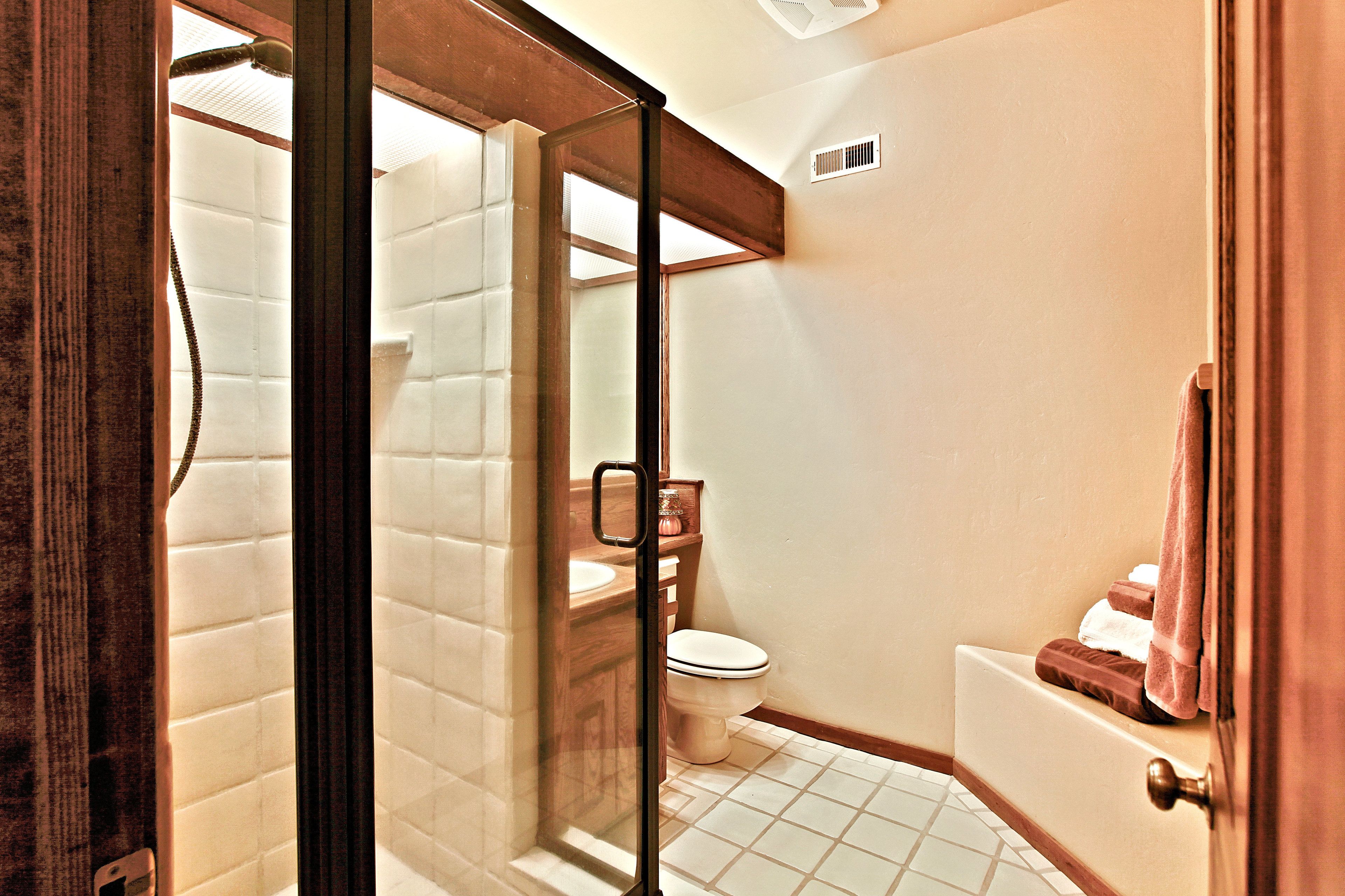 Une salle de bain avec une douche à parois de verre, des toilettes et une baignoire.