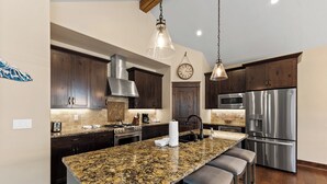 A modern kitchen with granite countertops, stainless steel appliances, and dark wooden cabinets. - Luxury Townhome w/ Gorgeous Slope Views and Close to Gondola, Shops & Dining! (Keystone)