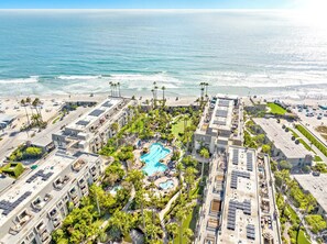 Un resort con piscina, acceso a la playa y vistas al océano.