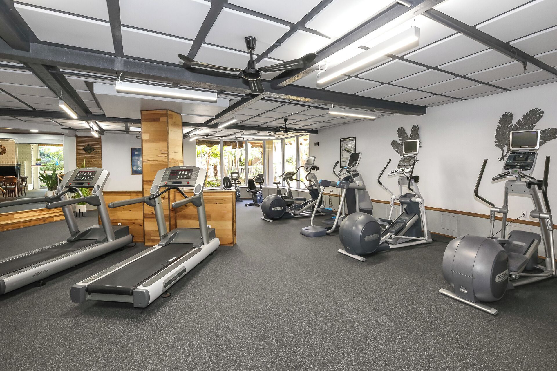 A gym with treadmills, elliptical machines, and stationary bikes.