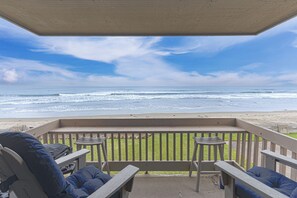 A covered outdoor seating area with a view of the ocean.