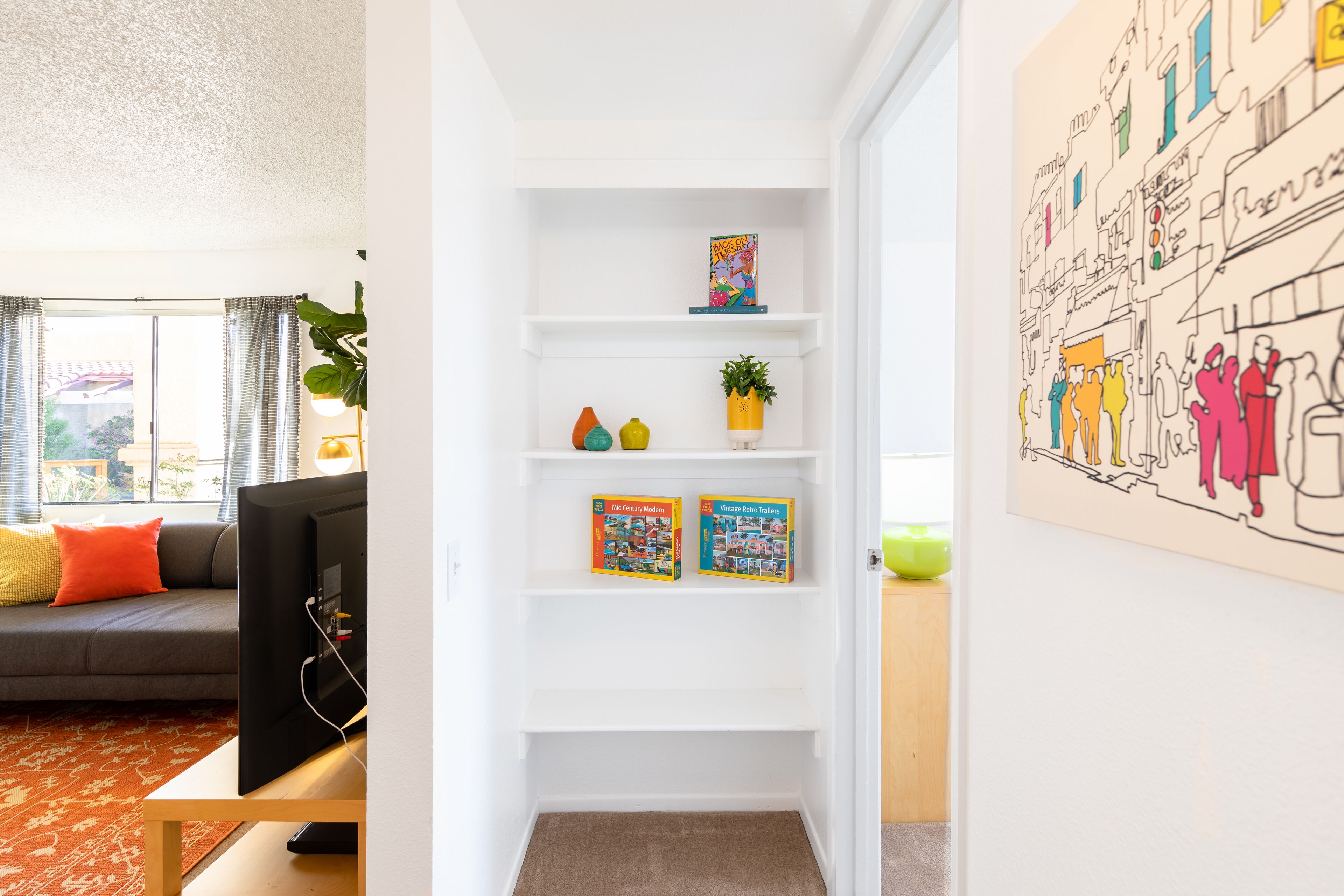 Una sala de estar moderna con un sofá, una mesita de centro y una estantería con libros y adornos.