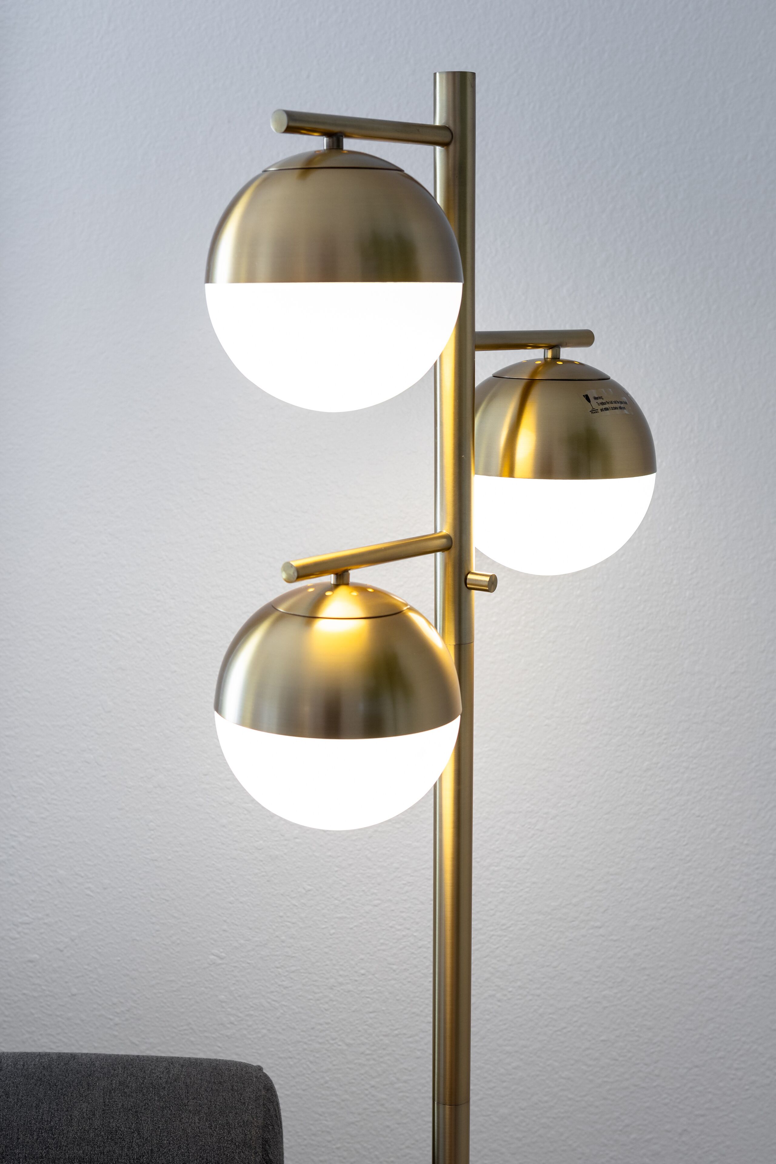 A floor lamp with three spherical shades and a metallic stand.