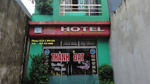 A multi-story building with a green facade, a sign indicating it's a hotel, and a visible entrance with a staircase. - Thanh Dat Hotel (Ninh Binh)