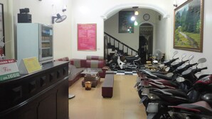 A reception area with a counter, seating, and multiple motorcycles parked. - Thanh Dat Hotel (Ninh Binh)