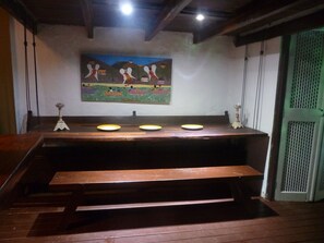 A wooden bench area with a mural on the wall. - Casa do barão (Paraty)
