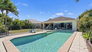 A rectangular swimming pool with clear water, surrounded by a tiled deck. - Relaxation & Space in a Canal Home (BANKSIA BEACH)