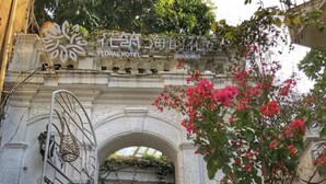 A hotel entrance with a wrought iron gate, a floral archway, and a sign indicating it is the Floral Hotel. - Floral Hotel Gulangyu Haiyun Garden (Xiamen)