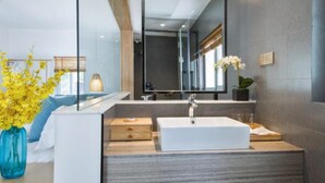 A modern bathroom with a large mirror, a white sink, and a wooden vanity. - Floral Hotel Gulangyu Haiyun Garden (Xiamen)
