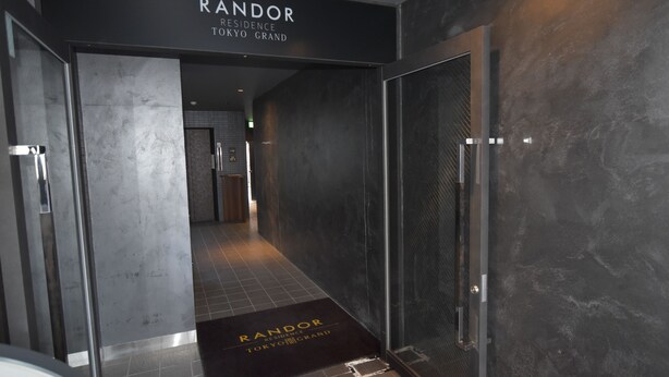 A hallway with a sign reading "RANDOR RESIDENCE TOKYO GRAND".