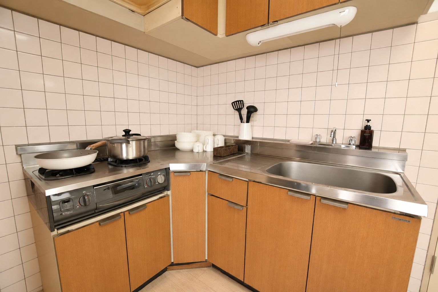 A modern kitchen with stainless steel appliances, wooden cabinets, and a large sink.