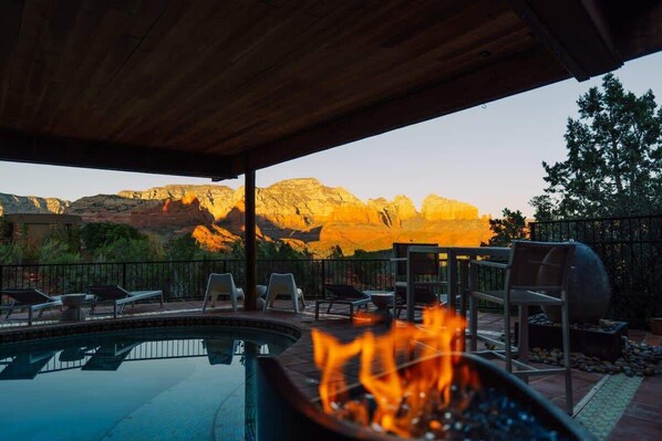 A pool with a fire feature, lounge chairs, and a view of mountains. - Eagle Dancer Guest Suite | Wellness Spa & Trails (Sedona)