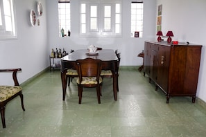 Enjoy meals in this cozy dining area with a round table and six chairs, surrounded by framed artwork and natural light.