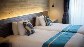 A double bed with a wooden headboard, two pillows, and a blue and white striped bedspread.