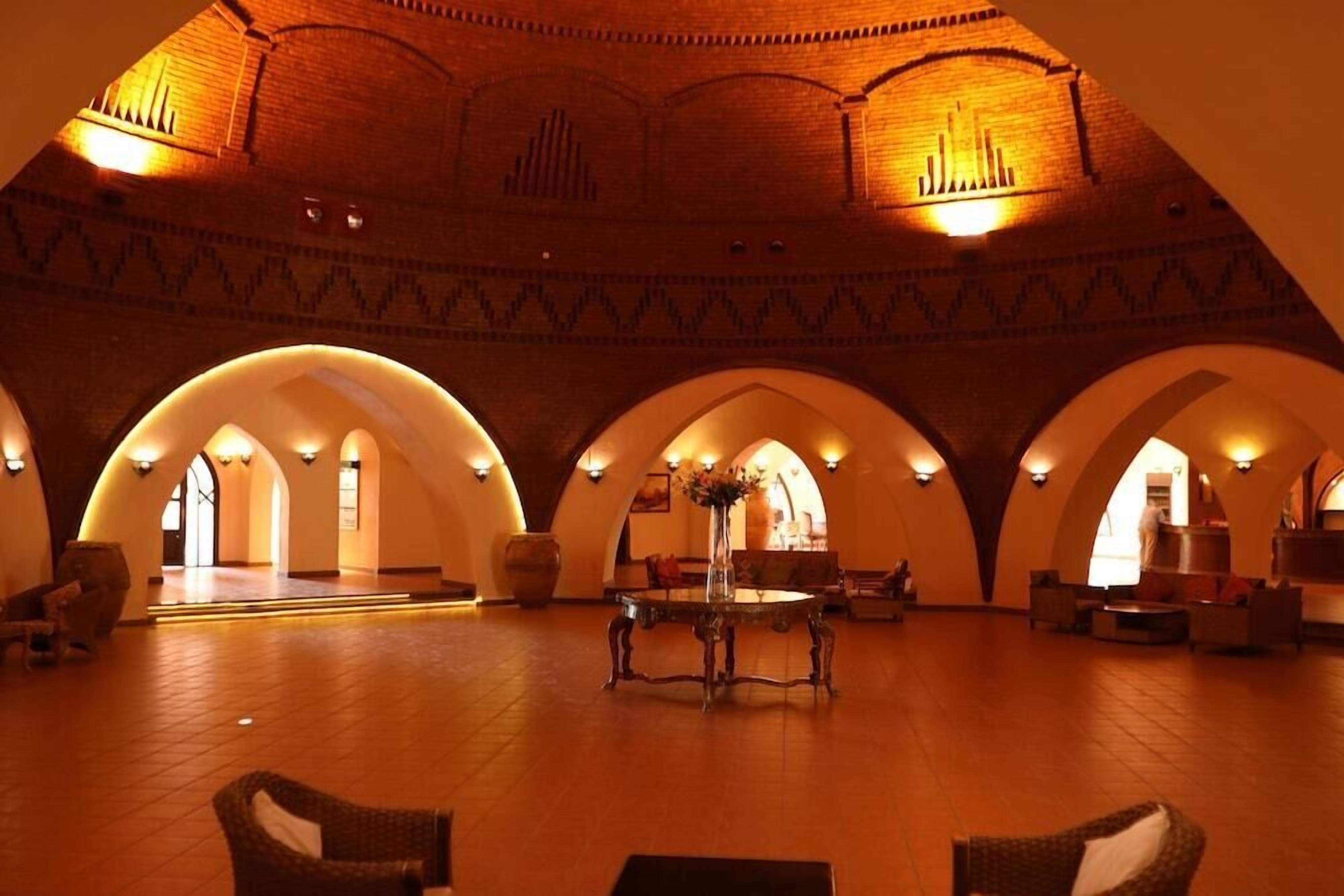 A spacious lobby with arched ceilings and a central table.