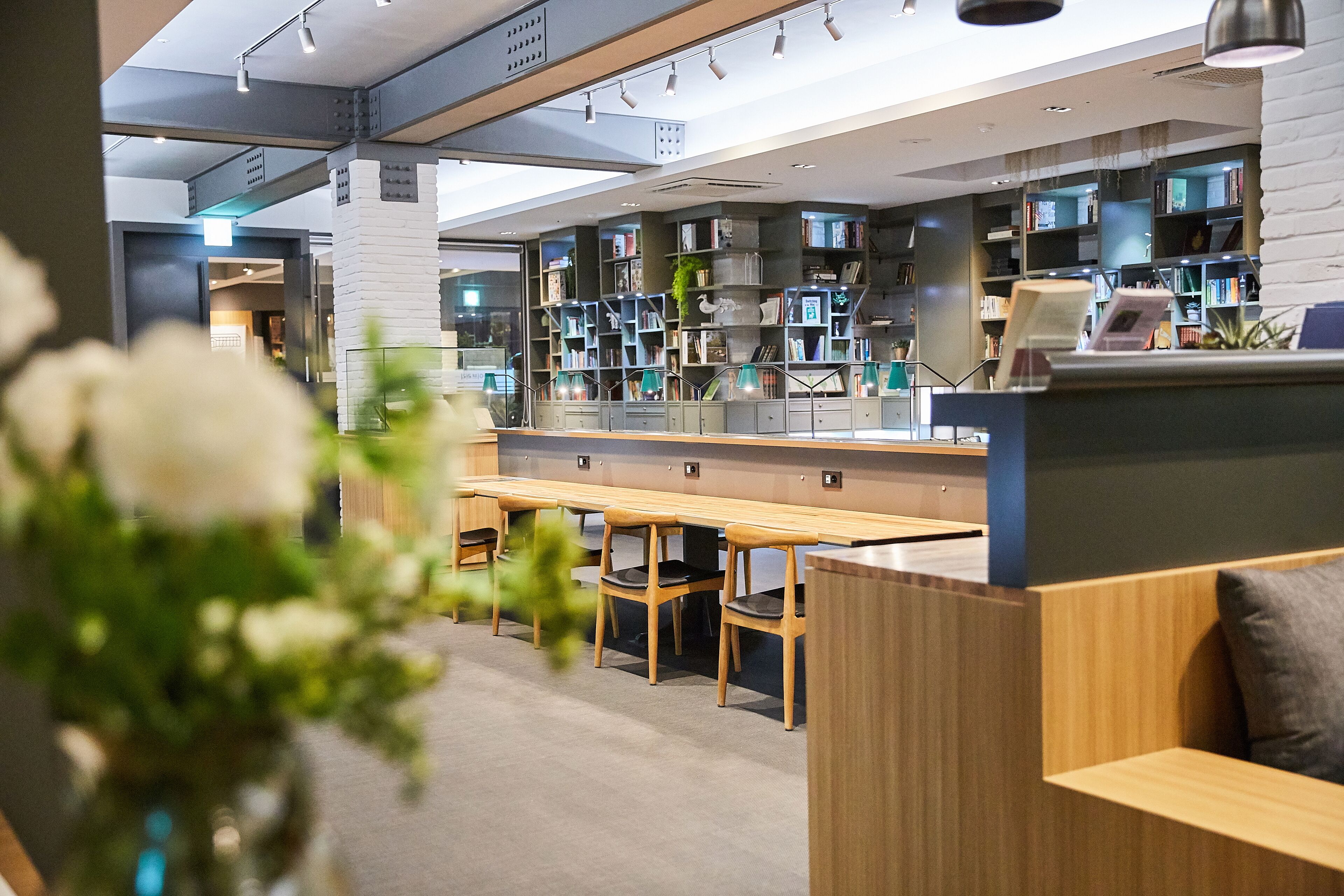 Una biblioteca moderna con estanterías, zonas de lectura y un mostrador de recepción.