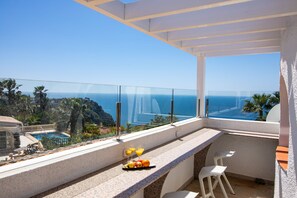 A balcony with a pool, a table with fruit and drinks, and a view of the ocean. - Casa Sabene - Javea, Costa Blanca (Javea)