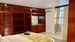 Un dormitorio con una cama grande, un armario de madera y un espejo.