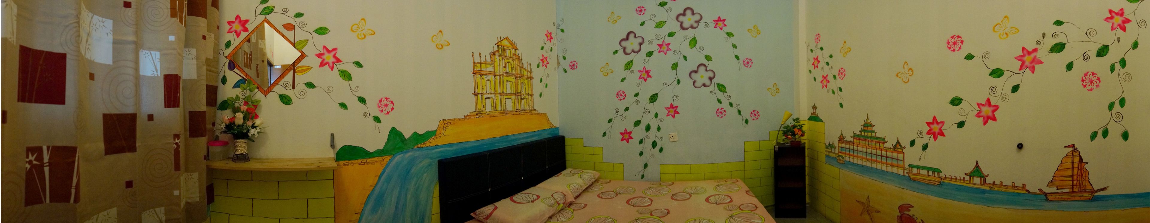 A child's bedroom with a bed, a dresser, and a wall decorated with colorful drawings of flowers, a castle, and a boat.