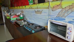 Een keuken met een gasfornuis, een spoelbak en een ingebouwde oven.