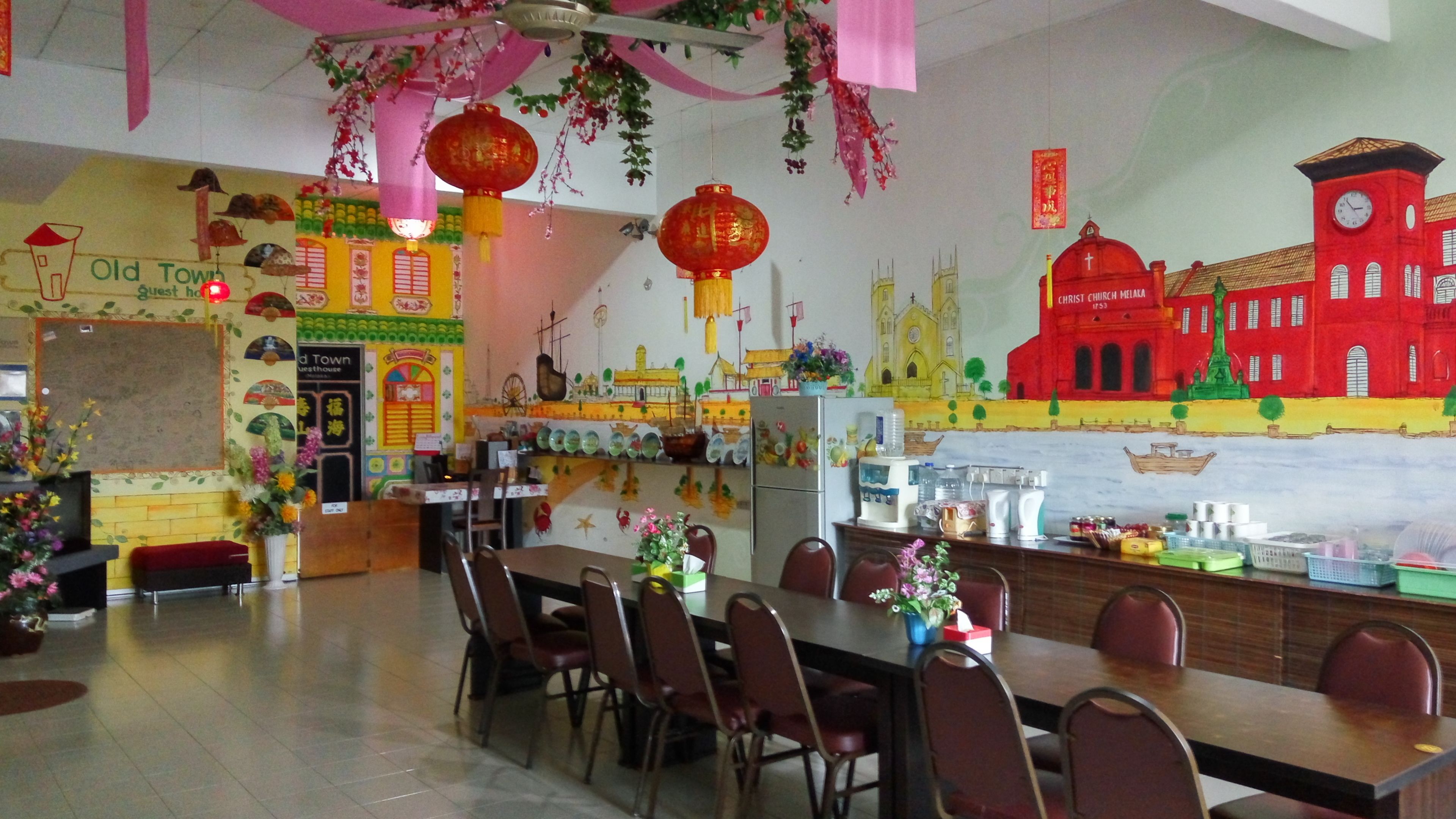 Un restaurante con una barra larga, sillas y un mural de edificios en la pared.