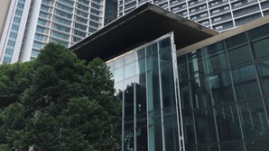 Een modern hoog gebouw met een opvallende glazen gevel en een uniek architectonisch ontwerp.