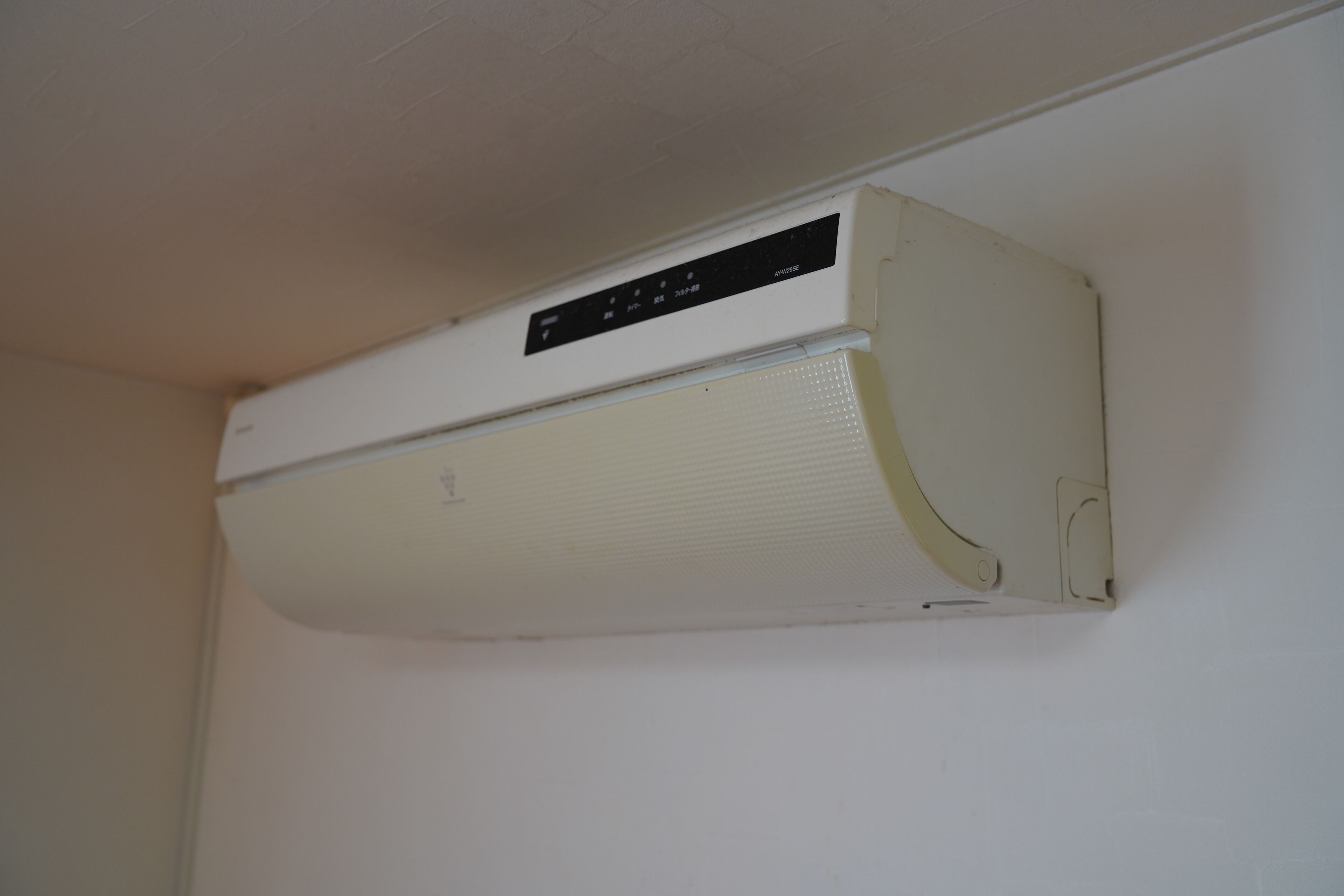 Un aire acondicionado blanco instalado en la pared con un panel de control.