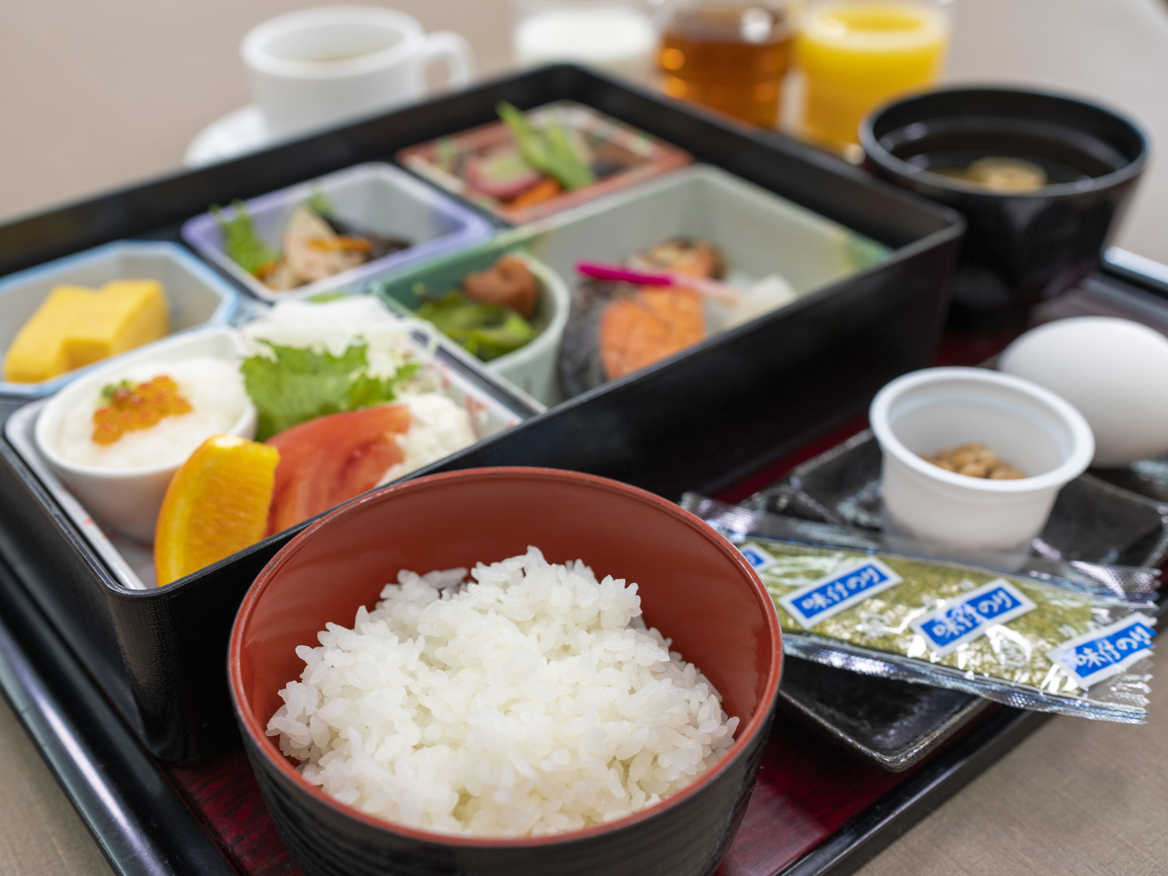 En bento-låda med olika sorters mat, inklusive ris, grönsaker och fisk.