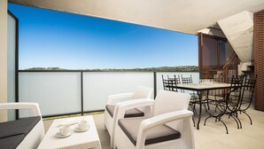 A balcony with wicker furniture, a table with cups, and a view of a body of water. - Arenal Dream IV - Javea, Costa Blanca (Javea)