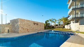 A swimming pool with stone walls and a clear blue water surface. - Arenal Dream IV - Javea, Costa Blanca (Javea)